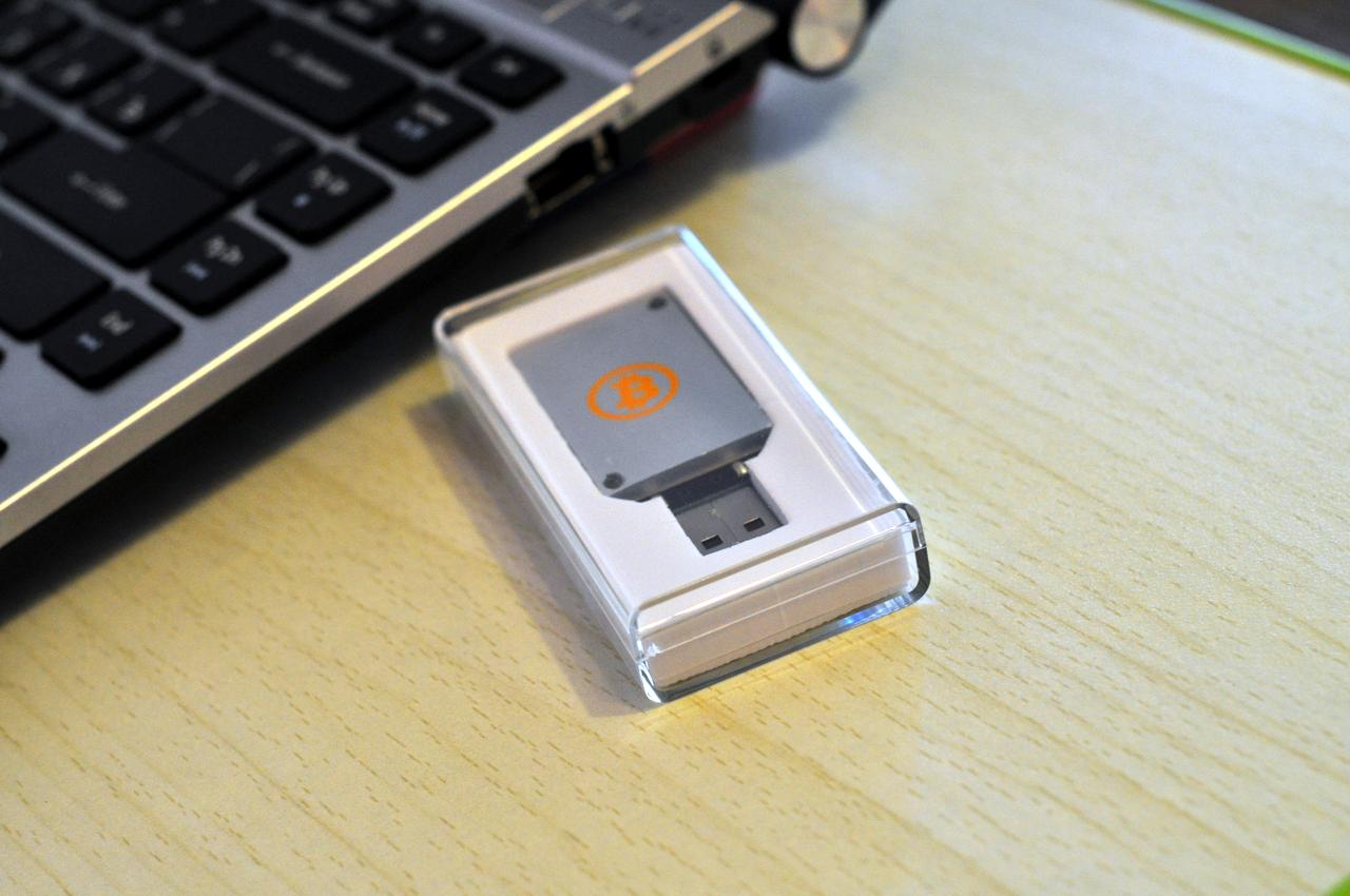 Фотография ASIC-майнера Block Erupter USB рядом с ноутбуком