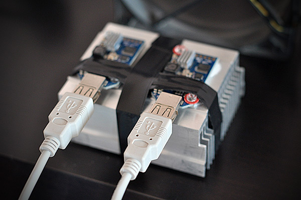 Фотография двух USB-майнеров Block Erupter, закреплённых на большом алюминиевом радиаторе