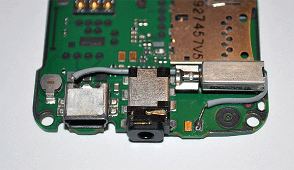 Фотография материнской платы Nokia 6300 с распаянным проводом от порта зарядки к порту мини-USB